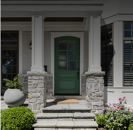 Green door with stone pillars and plants.