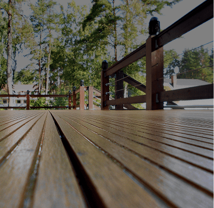 Wooden deck with trees in the background.